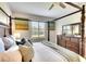 Comfortable main bedroom with a four-poster bed, dresser, soft lighting, and neutral décor at 8077 Sandstar Way, Sarasota, FL 34240