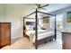 Spacious main bedroom featuring a four-poster bed, neutral tones, and a ceiling fan at 8077 Sandstar Way, Sarasota, FL 34240