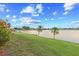 Picturesque lakeside view from the lush green lawn with palm trees and colorful flowering shrubs at 8531 Imperial Cir, Palmetto, FL 34221