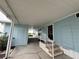 Exterior view of blue home with covered porch and stairway at 8531 Imperial Cir, Palmetto, FL 34221