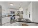 Updated kitchen with stainless steel appliances, white cabinets, stylish lighting, and mosaic tile backsplash at 8531 Imperial Cir, Palmetto, FL 34221