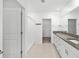 Bathroom with granite countertops, double sinks, and a large mirror, leading to a walk-in closet at 8656 40Th E Cir, Palmetto, FL 34221