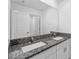 Bathroom with dual sinks, granite countertop, white cabinets, and a large mirror at 8656 40Th E Cir, Palmetto, FL 34221