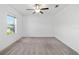 Neutral bedroom with a large window, ceiling fan, gray carpet, and freshly painted white walls at 8656 40Th E Cir, Palmetto, FL 34221