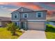 Two-story home with a blue exterior, light shutters, a two-car garage, and a well-manicured lawn at 8656 40Th E Cir, Palmetto, FL 34221
