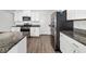 Kitchen with white cabinets, stainless steel appliances, stone countertops, and wood flooring at 8656 40Th E Cir, Palmetto, FL 34221