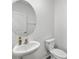 Clean powder room with pedestal sink, round mirror, and toilet in a well-lit space at 8656 40Th E Cir, Palmetto, FL 34221