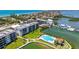 Aerial view of condo complex with community pool, lush landscaping, and marina on the intercoastal at 8897 Midnight Pass Rd # 407, Sarasota, FL 34242