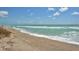 Expansive beach view featuring soft sand, gentle waves, and a clear, bright sky at 8897 Midnight Pass Rd # 407, Sarasota, FL 34242