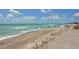 Inviting beach view with people enjoying the turquoise water and soft sandy shoreline under a bright sky at 8897 Midnight Pass Rd # 407, Sarasota, FL 34242