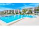 Large community pool surrounded by lounge chairs and lush landscaping, adjacent to condo buildings at 8897 Midnight Pass Rd # 407, Sarasota, FL 34242