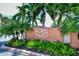 Sunrise Cove Yacht and Racquet Club signage with lush landscaping at 8897 Midnight Pass Rd # 407, Sarasota, FL 34242