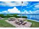 Exterior view of several picnic tables overlooking the water with the American flag flying above and a clear, sunny sky at 8897 Midnight Pass Rd # 407, Sarasota, FL 34242