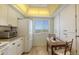 Bright kitchen with white cabinets and a cozy dining area near the ocean view window at 8897 Midnight Pass Rd # 407, Sarasota, FL 34242