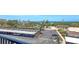 View from the condo balcony overlooking parking area and street with views of the beach in the distance at 8897 Midnight Pass Rd # 407, Sarasota, FL 34242