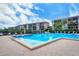 Gorgeous community pool with multiple lounging chairs and nearby condominium buildings creating a private space at 8897 Midnight Pass Rd # 407, Sarasota, FL 34242