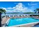 Community pool overlooking the bay with lounge chairs for relaxing poolside on a beautiful sunny day at 8897 Midnight Pass Rd # 407, Sarasota, FL 34242