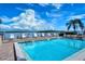 Community pool overlooking the bay with lounge chairs for relaxing poolside on a beautiful sunny day at 8897 Midnight Pass Rd # 407, Sarasota, FL 34242