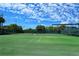 Outdoor tennis court surrounded by lush greenery and bright blue skies at 8897 Midnight Pass Rd # 407, Sarasota, FL 34242