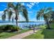 Scenic waterfront view with a brick pathway, docks and palm trees on a beautiful sunny day at 8897 Midnight Pass Rd # 407, Sarasota, FL 34242