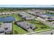 Stunning aerial view of the white one-story home and surrounding neighborhood with ponds and well-manicured lawns at 8982 Baroque Ter, Sarasota, FL 34240