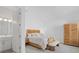 Bedroom with neutral tones, decorative pillows, and natural wood furniture at 8982 Baroque Ter, Sarasota, FL 34240