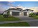Elegant home featuring a paved driveway leading to a spacious three-car garage, enhancing curb appeal at 8982 Baroque Ter, Sarasota, FL 34240
