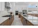 Open concept kitchen with stainless appliances, marble countertops, and white and wood cabinets at 8982 Baroque Ter, Sarasota, FL 34240