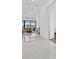Bright living room featuring white interior, marble floors, and large windows overlooking backyard at 8982 Baroque Ter, Sarasota, FL 34240