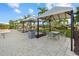 Outdoor patio with tables and chairs under shaded canopies, perfect for dining and relaxation at 8982 Baroque Ter, Sarasota, FL 34240