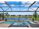 Screened-in pool with a luxurious spa, a tranquil lake view, and lush landscaping creating a serene outdoor oasis at 8982 Baroque Ter, Sarasota, FL 34240