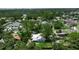 Aerial shot featuring a house with a metal roof and lush greenery in a vibrant neighborhood at 951 Varet Rd, Venice, FL 34293