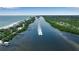 Aerial view of a boat speeding through the water near waterfront homes and docks by the ocean at 951 Varet Rd, Venice, FL 34293