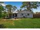 Backyard featuring a white house with a well maintained lawn and established trees for privacy at 951 Varet Rd, Venice, FL 34293