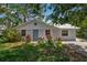 Charming single-story home featuring a well-maintained front yard with colorful landscaping and a light blue exterior at 951 Varet Rd, Venice, FL 34293