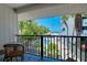 Inviting balcony overlooking the pool, palm trees, tables and chairs; a relaxing and private outdoor space at 1001 Point Of Rocks Rd # 207, Sarasota, FL 34242
