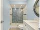 Bathroom featuring a glass shower, tiled walls, and porthole mirror at 1001 Point Of Rocks Rd # 207, Sarasota, FL 34242