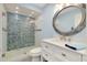 Modern bathroom boasts a glass-enclosed shower, quartz countertop, and nautical-themed mirror at 1001 Point Of Rocks Rd # 207, Sarasota, FL 34242