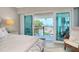 Bedroom with a comfy chair and ocean view from sliding glass doors to the private balcony at 1001 Point Of Rocks Rd # 207, Sarasota, FL 34242