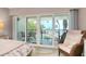 Bright bedroom with a comfy chair and beautiful ocean view from sliding glass doors to the private balcony at 1001 Point Of Rocks Rd # 207, Sarasota, FL 34242