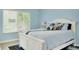 Charming bedroom features a cozy blue color palette and ample natural light from a large window at 1001 Point Of Rocks Rd # 207, Sarasota, FL 34242
