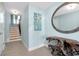 Hallway featuring a staircase, driftwood table and large circular mirror at 1001 Point Of Rocks Rd # 207, Sarasota, FL 34242