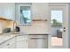 Close up of marble countertops, stainless steel dishwasher and view to balcony at 1001 Point Of Rocks Rd # 207, Sarasota, FL 34242