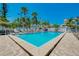 Outdoor pool surrounded by lush landscaping, lounge chairs and white picket fence at 1001 Point Of Rocks Rd # 207, Sarasota, FL 34242