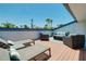 This rooftop deck features lounge seating with views of palm trees and the sunny sky at 1001 Point Of Rocks Rd # 207, Sarasota, FL 34242