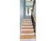 Staircase features wood treads and wrought iron spindles with natural light at 1001 Point Of Rocks Rd # 207, Sarasota, FL 34242