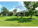 Large backyard with a wooden playset, lush grass, and mature trees, perfect for outdoor activities at 11502 Golden Bay Pl, Bradenton, FL 34211