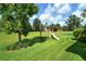 Backyard featuring a wooden playset with swings and a slide on a well-maintained lawn at 11502 Golden Bay Pl, Bradenton, FL 34211