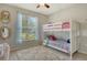 Bright bedroom with a bunk bed, large window and colorful rug, creating a cozy and inviting space at 11502 Golden Bay Pl, Bradenton, FL 34211