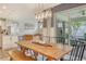 Open dining area with a wooden table, modern chandelier, and access to the outdoor patio seating area at 11502 Golden Bay Pl, Bradenton, FL 34211